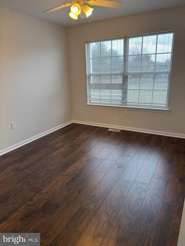 unfurnished room with ceiling fan, a healthy amount of sunlight, and dark hardwood / wood-style floors