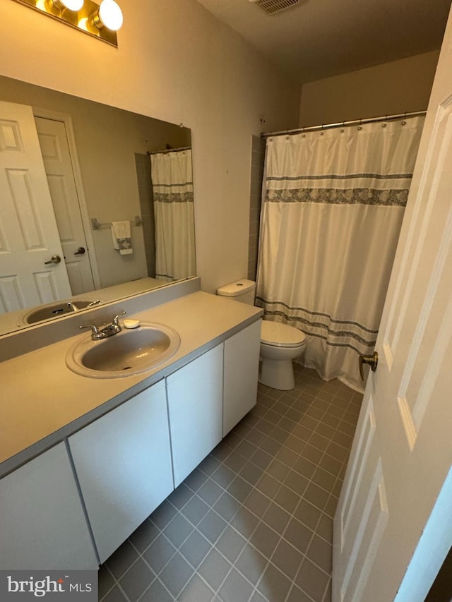 bathroom featuring vanity, tile patterned floors, and toilet