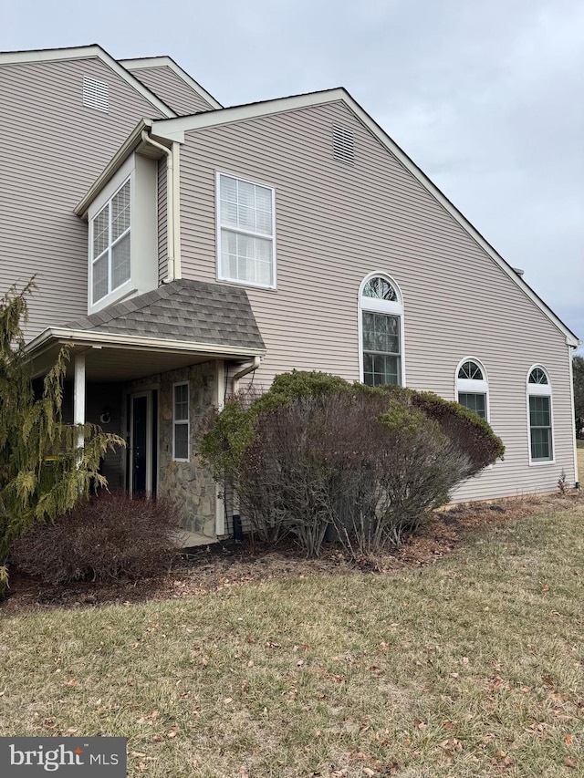 view of side of home with a lawn