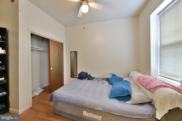 bedroom with ceiling fan, light wood-type flooring, and a closet