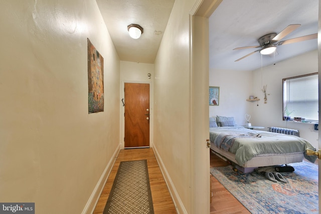 bedroom featuring radiator, ceiling fan, and hardwood / wood-style flooring