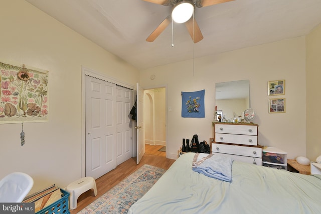 bedroom featuring ceiling fan, a closet, and light hardwood / wood-style flooring