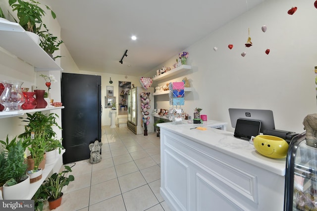 kitchen with light tile patterned floors and white cabinets