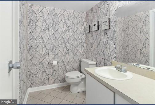 bathroom featuring vanity, toilet, and tile patterned flooring