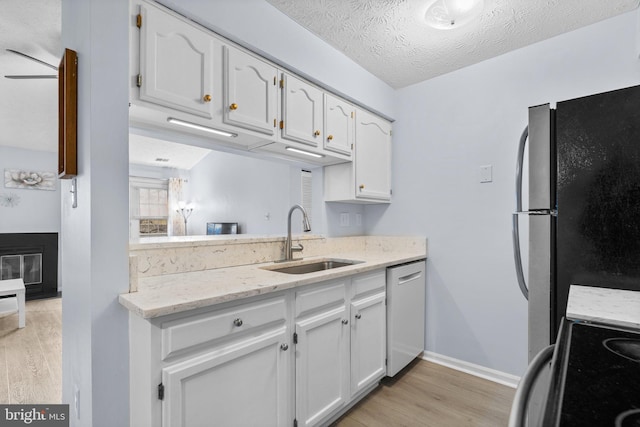 kitchen with white cabinetry, sink, light hardwood / wood-style flooring, and stainless steel appliances