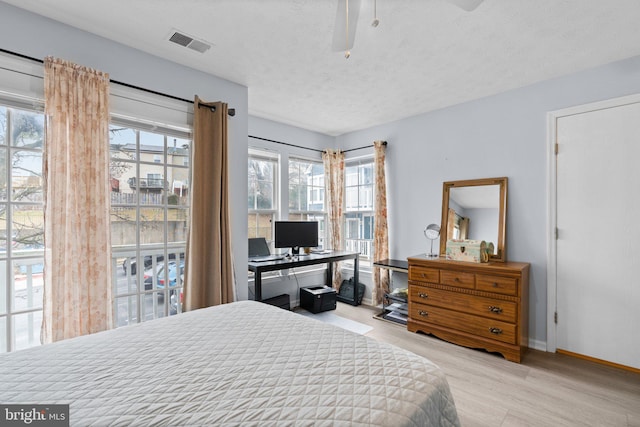 bedroom with ceiling fan, access to outside, a textured ceiling, and light wood-type flooring