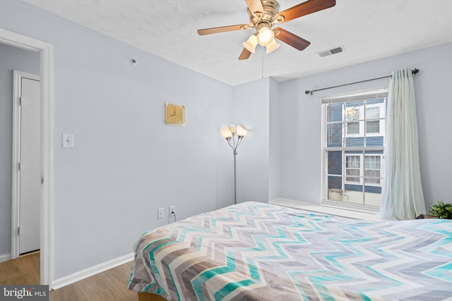 bedroom with a textured ceiling and light wood-type flooring