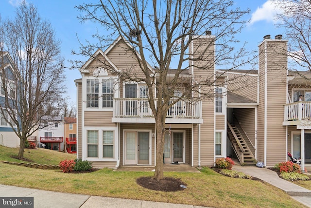 multi unit property with a front yard and a balcony