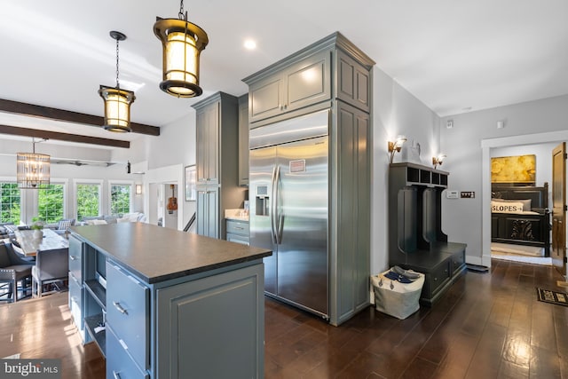 kitchen with gray cabinets, a center island, beamed ceiling, dark hardwood / wood-style flooring, and built in fridge