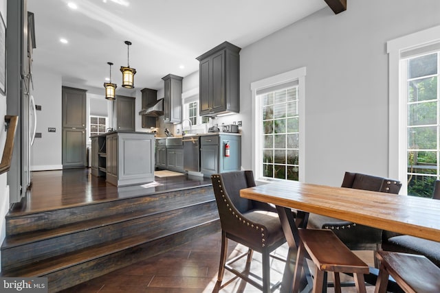 dining room featuring sink, dark hardwood / wood-style floors, and beam ceiling