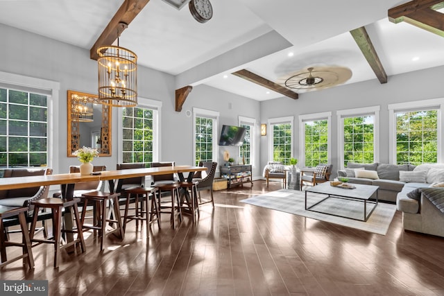 interior space featuring beam ceiling, a wealth of natural light, and ceiling fan with notable chandelier