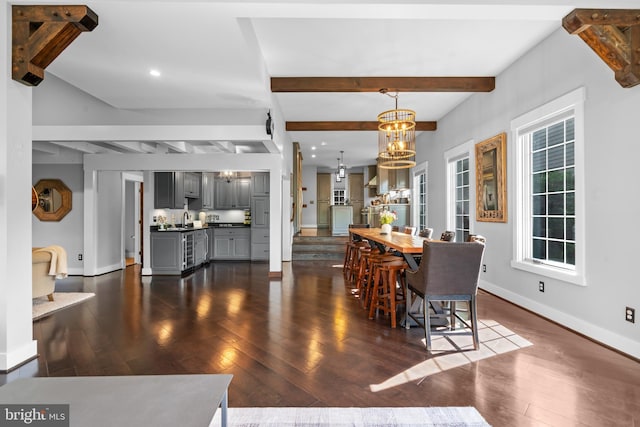 dining area with dark wood-type flooring, beam ceiling, and a notable chandelier