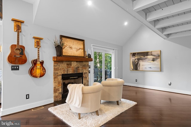 living room featuring dark wood-type flooring, lofted ceiling with beams, and a fireplace