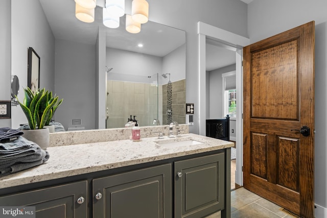 bathroom featuring a shower with shower door, tile patterned floors, vanity, and a notable chandelier