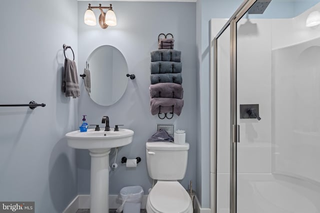 bathroom with sink, an enclosed shower, and toilet