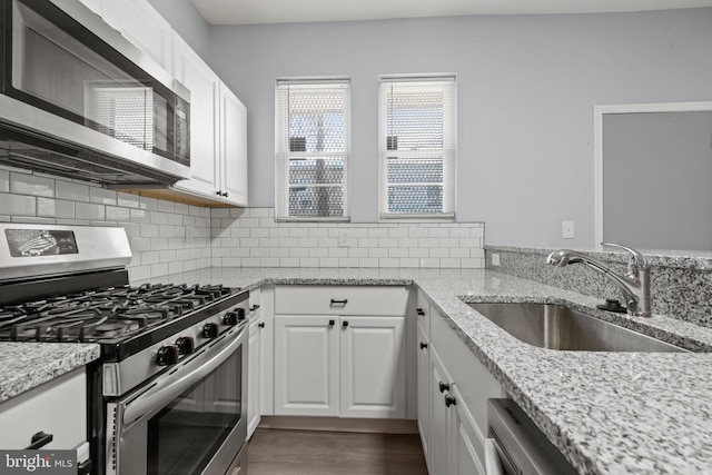 kitchen featuring light stone countertops, sink, white cabinetry, and appliances with stainless steel finishes