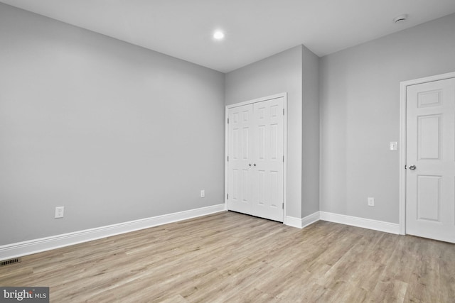 unfurnished bedroom with light hardwood / wood-style floors and a closet