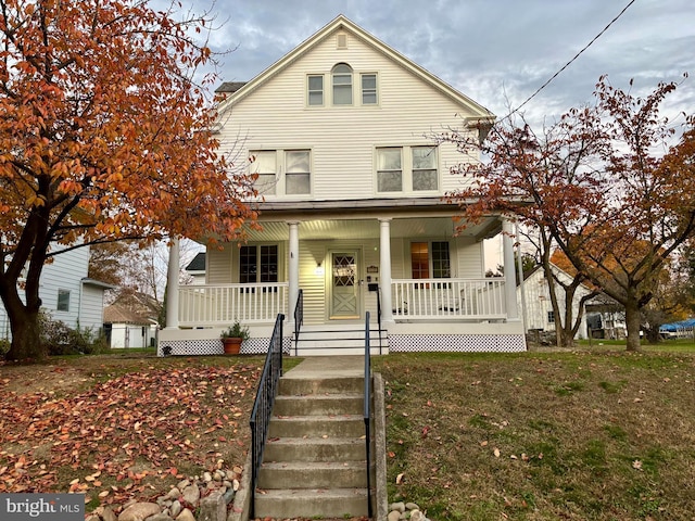 view of front of home featuring covered porch and a front lawn