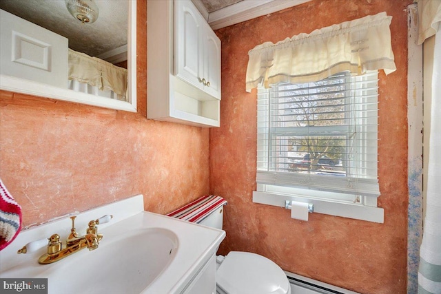 bathroom with a baseboard radiator, vanity, crown molding, and toilet