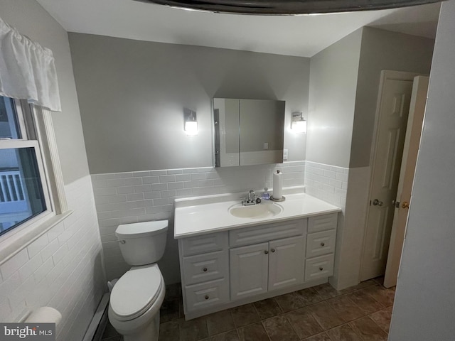 bathroom with toilet, tile walls, and vanity