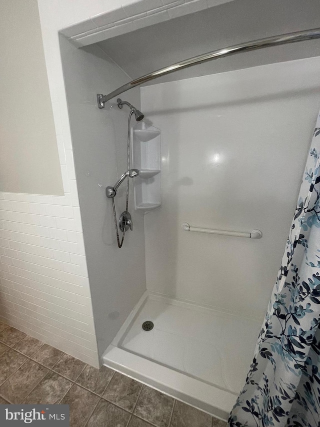 bathroom featuring walk in shower and tile patterned flooring