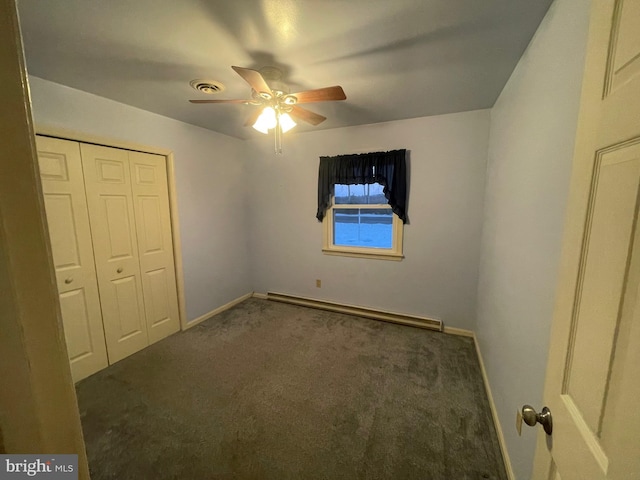 unfurnished bedroom with ceiling fan, a baseboard radiator, dark carpet, and a closet