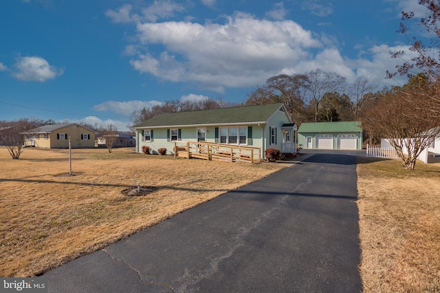 ranch-style house with a garage, an outbuilding, and a front lawn