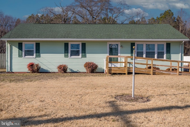 single story home with a wooden deck and a front yard