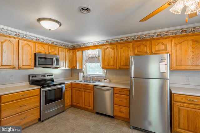 kitchen with stainless steel appliances, crown molding, sink, and ceiling fan