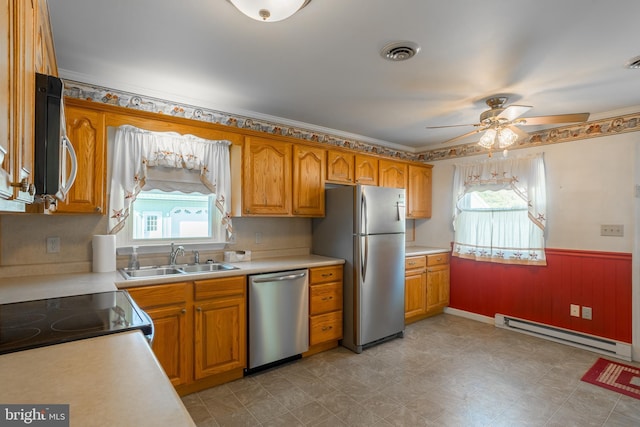 kitchen with ceiling fan, stainless steel appliances, sink, and a baseboard heating unit