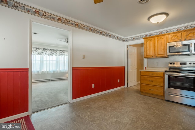 kitchen with crown molding, a baseboard radiator, ceiling fan, and appliances with stainless steel finishes