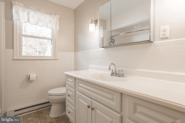 bathroom featuring tile patterned flooring, tile walls, vanity, a baseboard radiator, and toilet