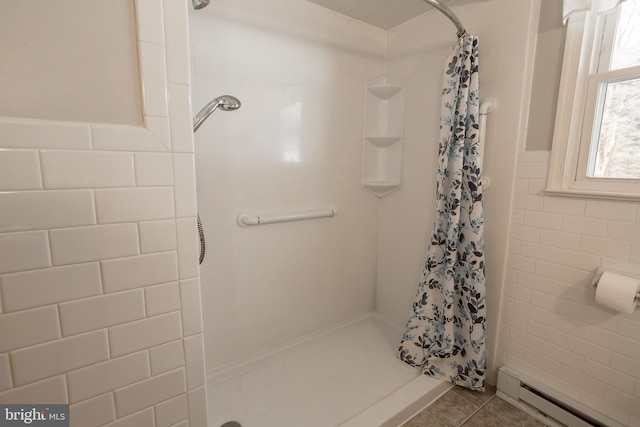 bathroom featuring baseboard heating, tile patterned flooring, a shower with shower curtain, and tile walls