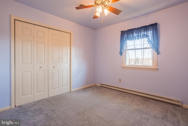 unfurnished bedroom with a baseboard heating unit, carpet floors, a closet, and ceiling fan