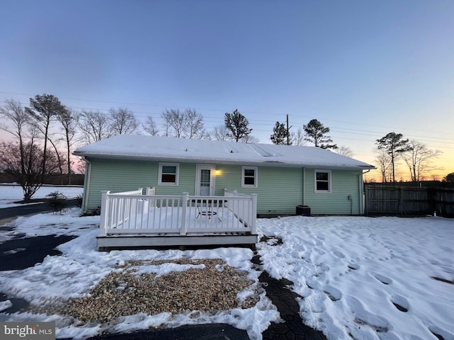 snow covered rear of property featuring a deck