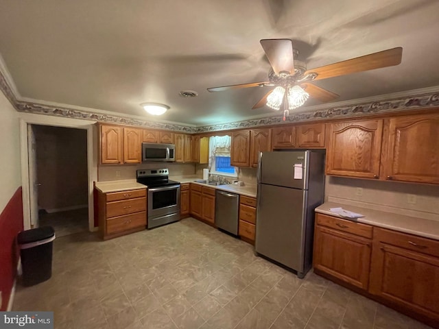 kitchen with ceiling fan, sink, stainless steel appliances, and ornamental molding