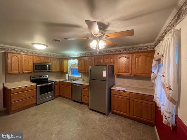 kitchen featuring ceiling fan, sink, appliances with stainless steel finishes, and ornamental molding