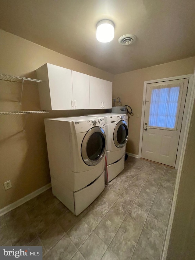 washroom featuring cabinets and independent washer and dryer