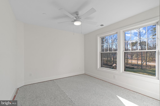 empty room with a ceiling fan, visible vents, and baseboards