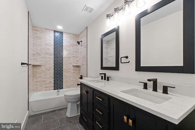 full bath with toilet, double vanity, a sink, and visible vents