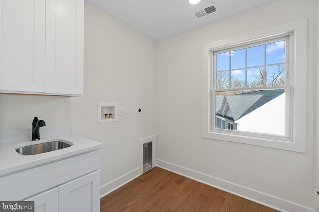 clothes washing area with baseboards, visible vents, hookup for an electric dryer, washer hookup, and a sink