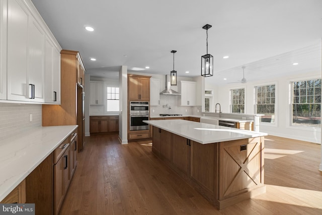 kitchen with wall chimney exhaust hood, appliances with stainless steel finishes, dark wood-type flooring, and recessed lighting