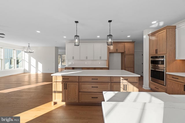 kitchen featuring dark wood-style floors, pendant lighting, recessed lighting, backsplash, and double oven