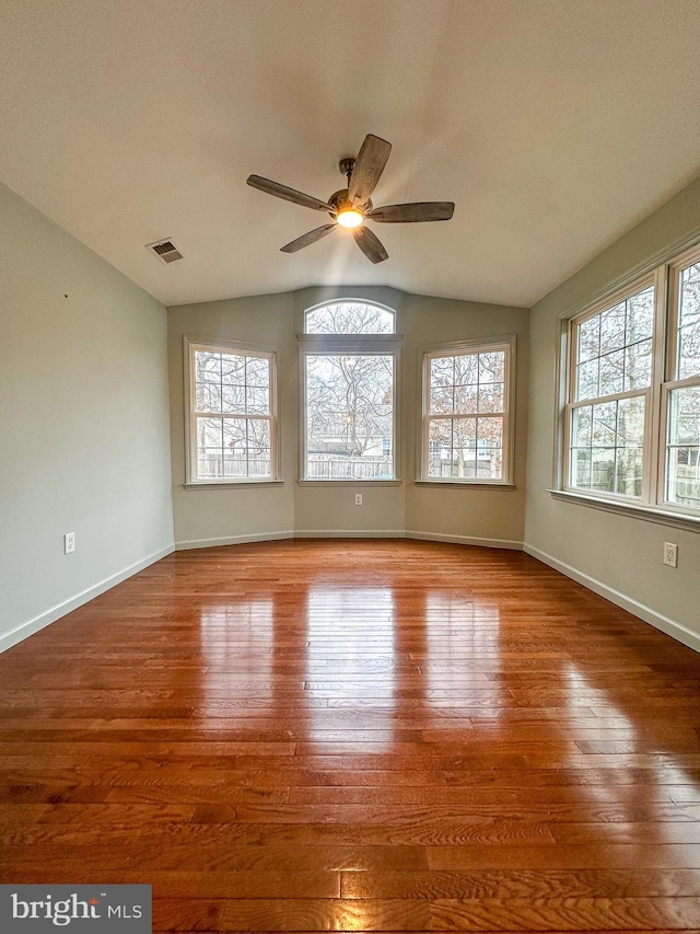 unfurnished room with hardwood / wood-style flooring, ceiling fan, and vaulted ceiling