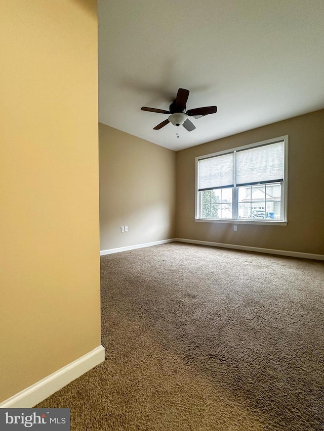 empty room with ceiling fan and carpet