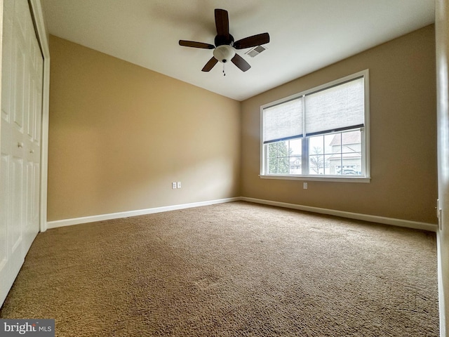 carpeted empty room featuring ceiling fan