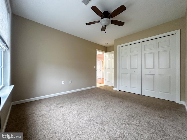 unfurnished bedroom featuring ceiling fan, carpet, and a closet