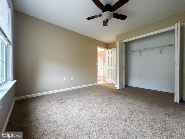 unfurnished bedroom with ceiling fan, carpet, and a closet