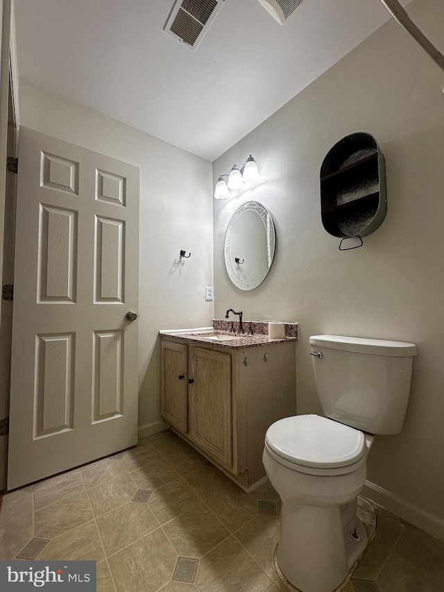 bathroom with toilet, tile patterned flooring, and vanity