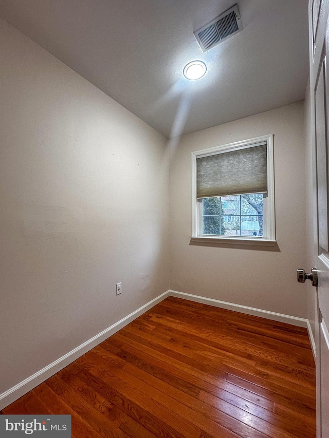 unfurnished room featuring dark wood-type flooring